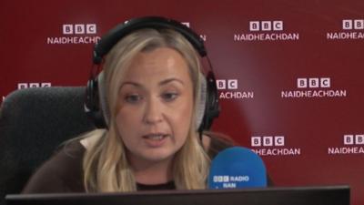 Karen Elder a' leughadh nan naidheachdan ann an stiùdio rèidio