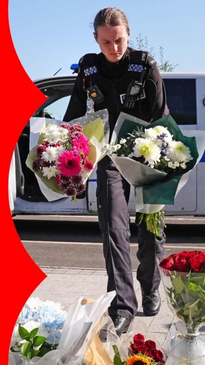 A police officer lays flowers following the crash on the A66.