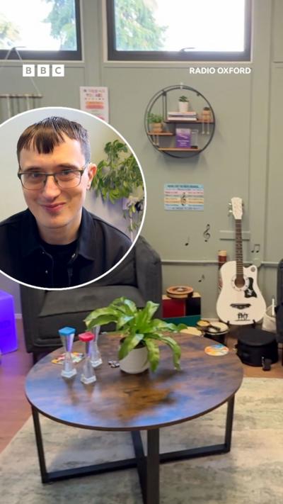 A sensory room, with a white guitar in the background and a photo of Andy Baker MBE in a circle.
