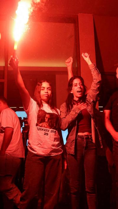 Natali Zangauker holding a red flare and Einav Zangauker, the sister and mother of Israeli hostage Matan Zangauker