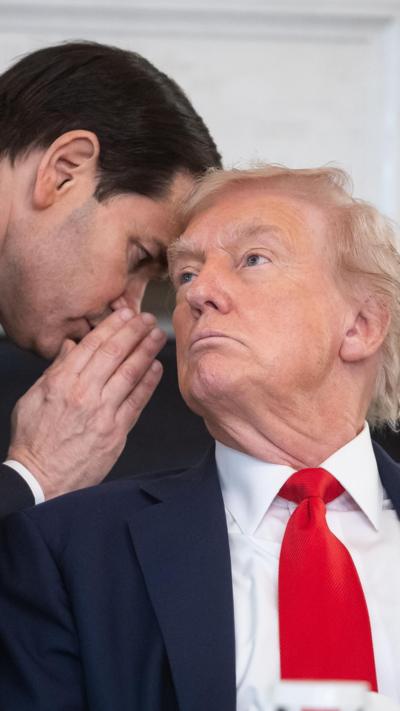 Marco Rubio talking to Donald Trump with his hand up