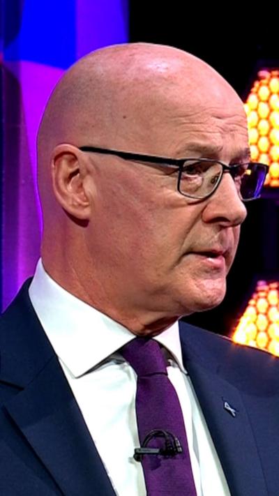 A head and shoulders shot of First Minister John Swinney in a studio setting.