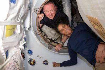 American astronauts Barry Wilmore and Sunita Williams posing for a portrait inside the vestibule between the forward port on the International Space Station