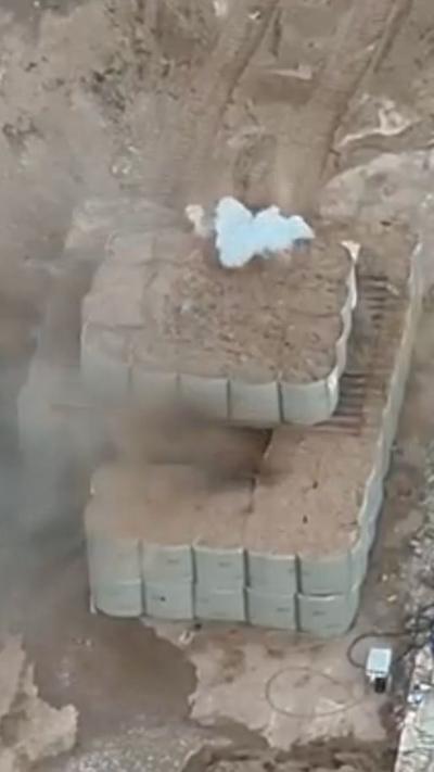 Smokes rises through dozens of sandbags as a bomb is detonated