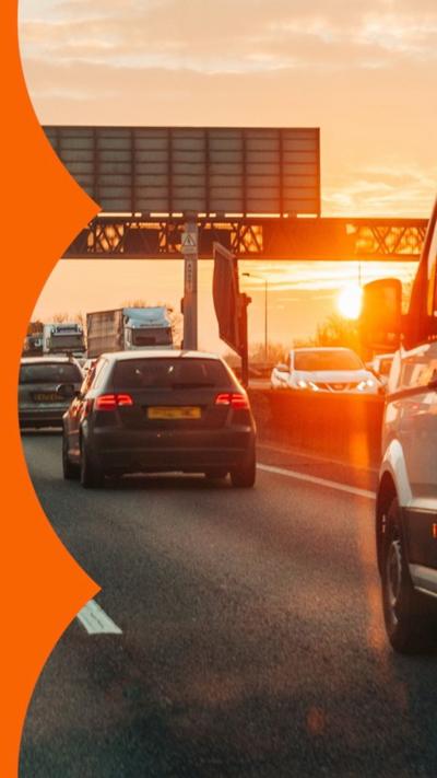 Traffic on a busy multi-lane road, as the sun sets