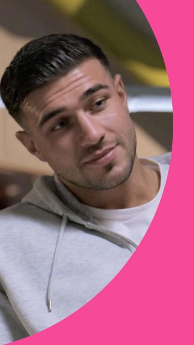 Tommy Fury has slicked back dark hair. He is wearing a white T-shirt and a grey hoodie.
