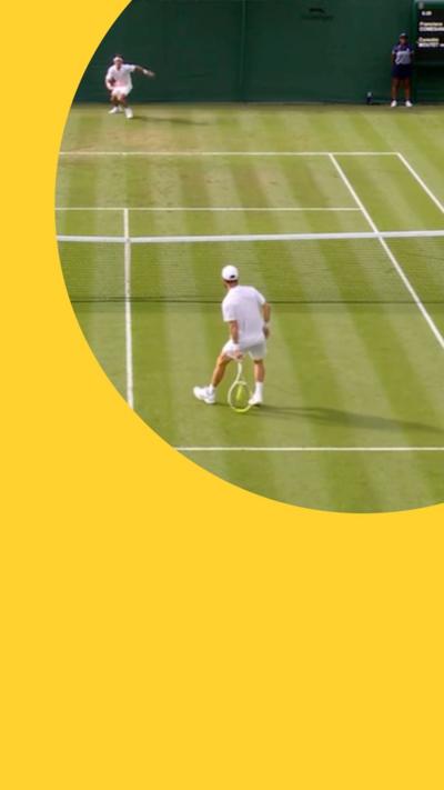 Two people drssed  in white on a grass tennis court