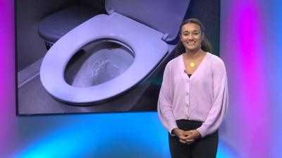 Nina in the studio with a toilet in the screen