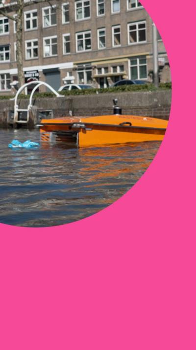 An orange floating robot gathers plastic waste in an urban waterway