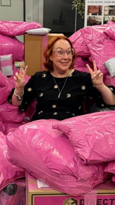A woman surrounded by pink bags