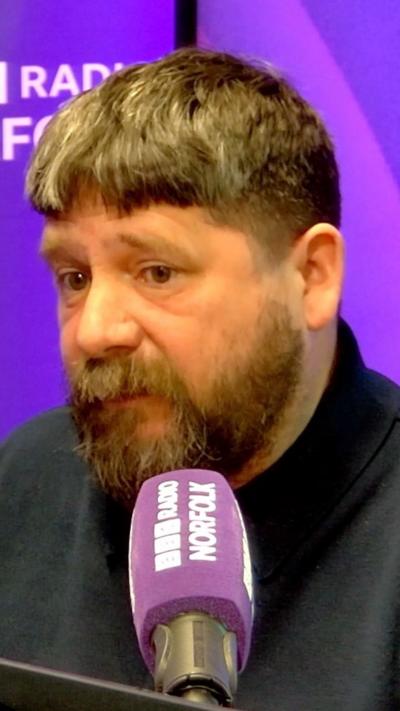 Bearded man sits in radio studio