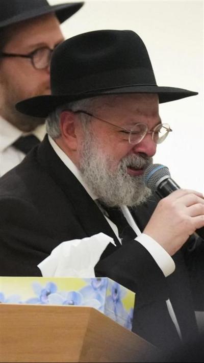 Rabbi Ulman crying while talking into a microphone