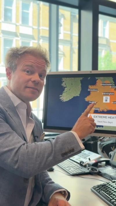 Simon King pointing at a computer screen with a UK map on.