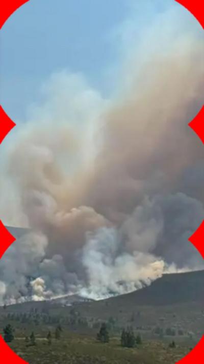 Plumes of smoke at the top of a hill.