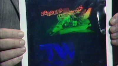 A hologram of a spaces shuttle model with the Tomorrow's World logo below and "seasons greetings" above.