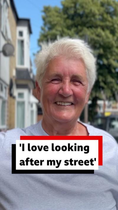 A smiling Eileen Harland is pictured on her street outside on a sunny day.