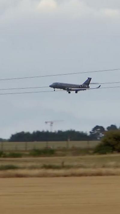 Grey jet flying over field