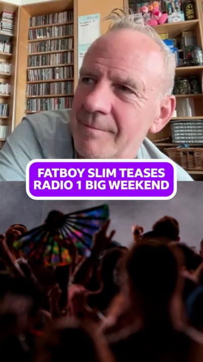 BBC Radio 1 Big Weekend headliner Fatboy Slim sitting in a room with lots of CDs behind him. .