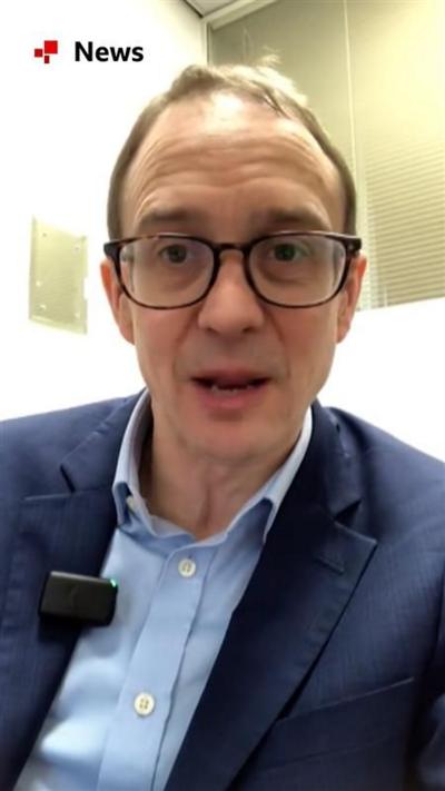 BBC political editor Chris Mason sits in an office, he wears a dark blue suit jacket and light blue shirt 