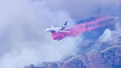 Plane drops fire retardant in path of LA wildfire