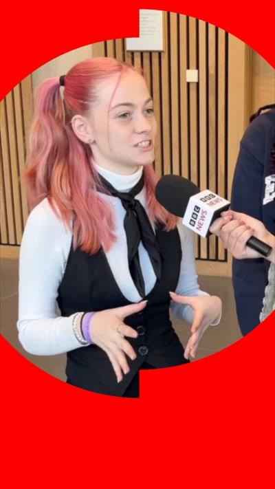 A teenage girl speaks into a BBC News mic. She has pink hair in pigtails and wears a black and white outfit