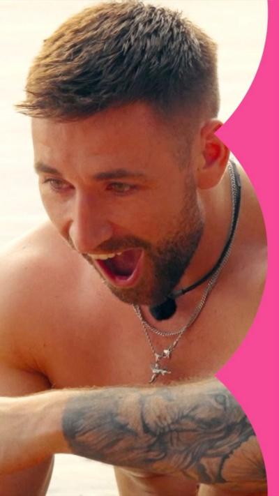 A topless man looks stunned. He has tattoos and a necklace.