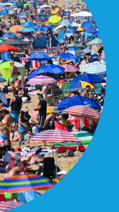 A Bournemouth beach full of people sitting under brightly-coloured sun umbrellas.