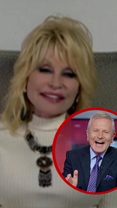 Dolly Parton, with blonde hair and a white jumper on, smiles at the camera while there is a smaller picture of presenter Peter Levy superimposed over the main image.