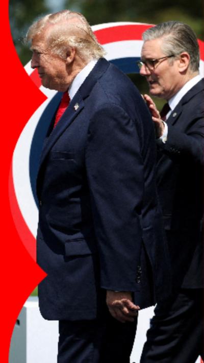 Keir Starmer, a man with short grey hair wearing a dark suit, walks alongside Donald Trump, a man with blonde hair wearing a dark blue suit, with a hand placed on his back.