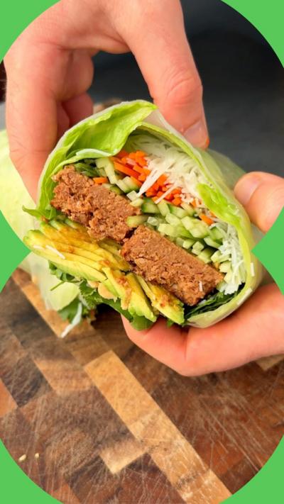 A cross-section of a giant summer roll showing chopped vegetables and non-meat mince.