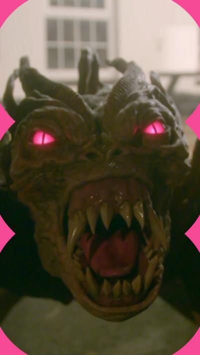 Shadowy monster with spikes sticking out of back crawls up a car in front of a house during the night.