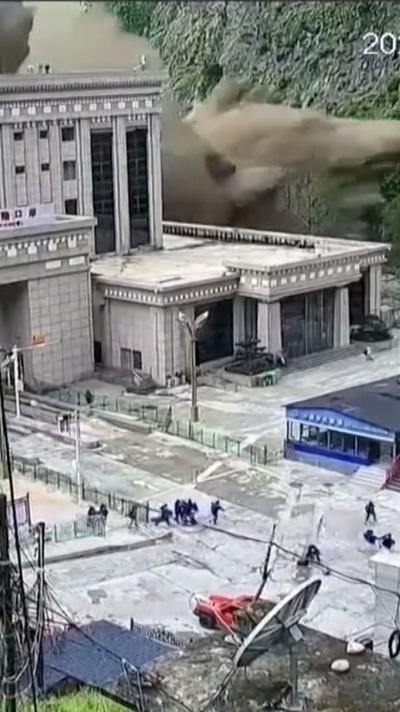 A flash flood coming over the top of a building