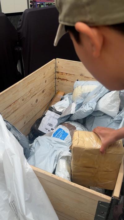 Person rummaging through crate of parcels