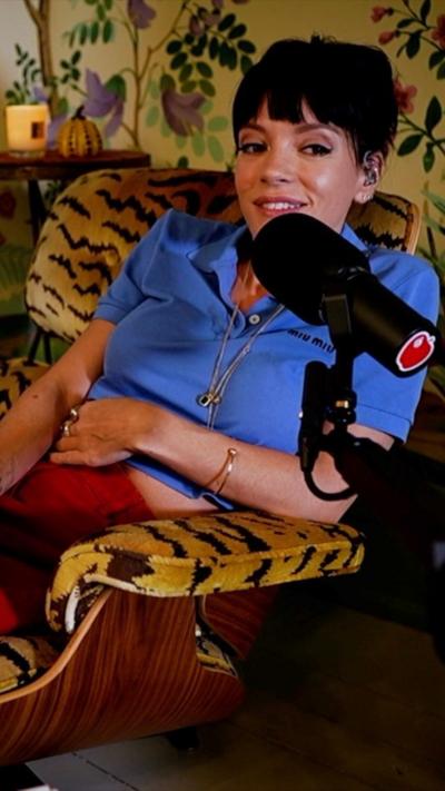 Lily Allen sitting on a tiger print chair wearing a blue top