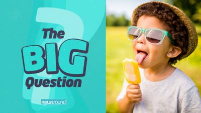 A child with sunglasses licking an ice lolly