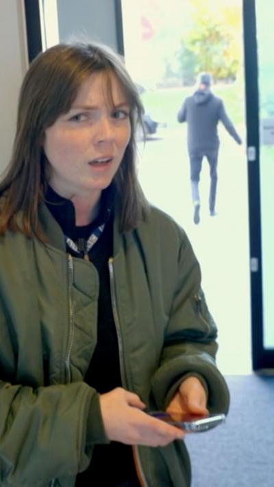 Girl looking doubtful at the entrance to a modern building