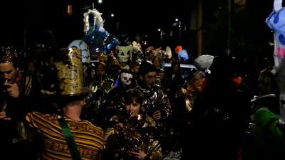 Group of people playing brass instruments, surrounded by Halloween theme lanterns.