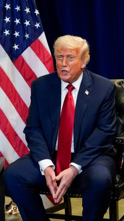 Donald Trump sat next to a US flag