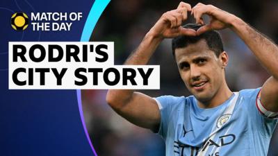Rodri makes a heart with his hands above his head