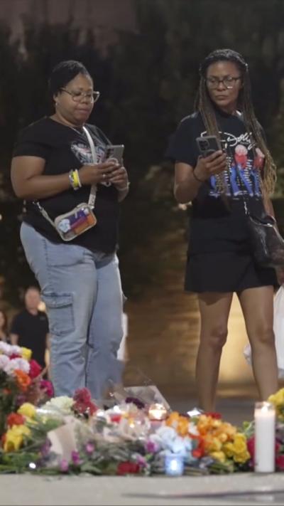 Two women looking at flower tributes for Dolly Parton in Nashville