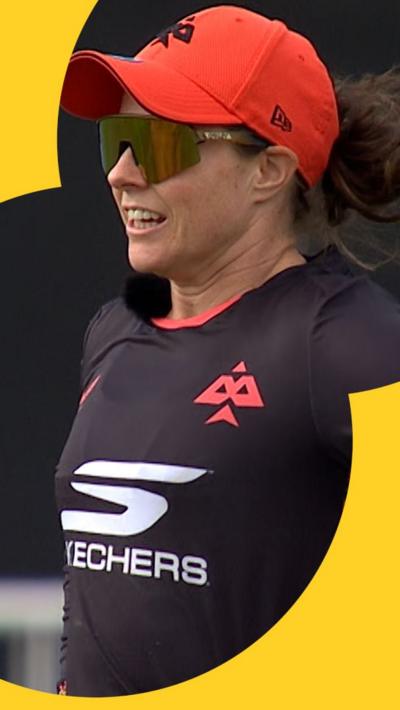 Tammy Beaumont talking to the commentators using her microphone on-field