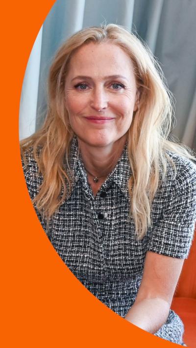 Gillian Anderson sat on an orange couch