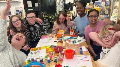 kids around a table doing painting crafts.