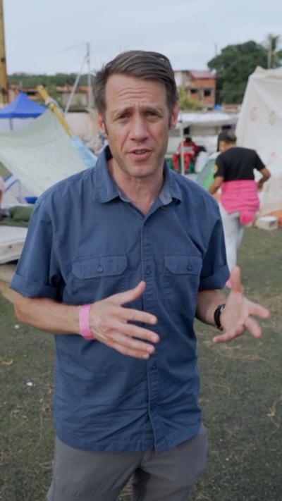 Will Grant in blue shirt at a campsite