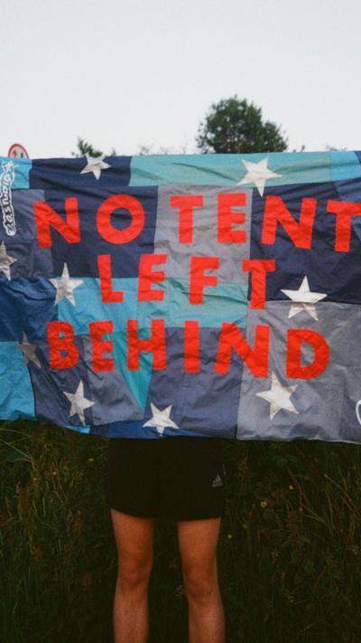 A patterned sleeping bag with shades of blue. On the front in red lettering it says No Tent Left Behind