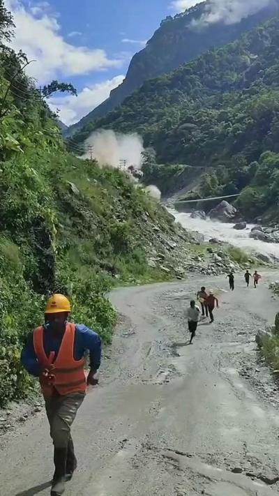 Men run from valley as water crashes down behind them