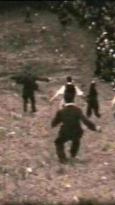Black and white image of men in suits running down hill