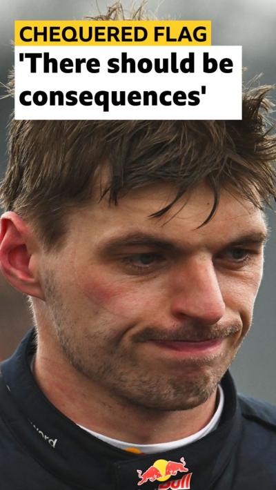 Max Verstappen grimaces with Red Bull logo showing on his race suit 