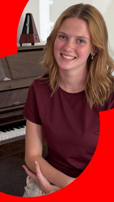 Freya Terris is a young woman with shoulder length light brown hair, which is hanging in loose waves around her face. She is smiling at the camera.