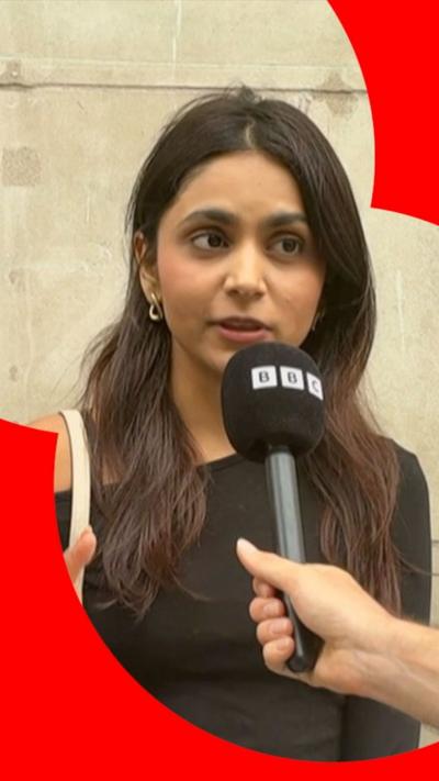 A young woman speaks into a BBC microphone.